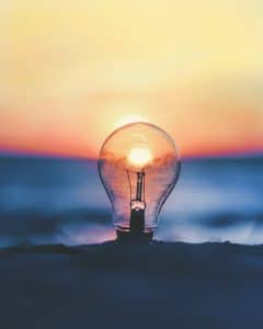 Light Bulb in the sand with a sunset 
